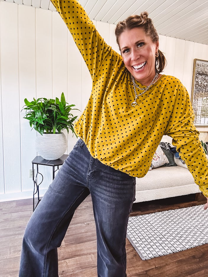 Thin, lightweight mustard long sleeved top with black polka dots throughout and elastic bubble hem.