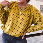 Thin, lightweight mustard long sleeved top with black polka dots throughout and elastic bubble hem.