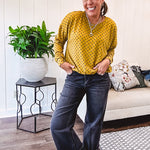Thin, lightweight mustard long sleeved top with black polka dots throughout and elastic bubble hem.