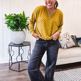 Thin, lightweight mustard long sleeved top with black polka dots throughout and elastic bubble hem.