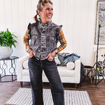 Washed black denim vest with ruffles at collar and sleeves, front pockets and silver buttons down the front.