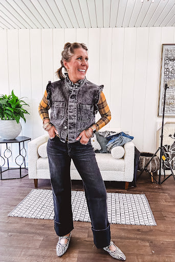 Washed black denim vest with ruffles at collar and sleeves, front pockets and silver buttons down the front.