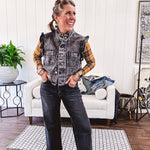 Washed black denim vest with ruffles at collar and sleeves, front pockets and silver buttons down the front.