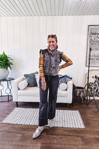 Washed black denim vest with ruffles at collar and sleeves, front pockets and silver buttons down the front.