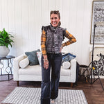 Washed black denim vest with ruffles at collar and sleeves, front pockets and silver buttons down the front.