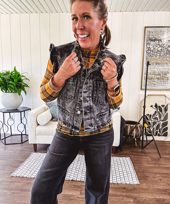 Washed black denim vest with ruffles at collar and sleeves, front pockets and silver buttons down the front.