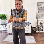 Washed black denim vest with ruffles at collar and sleeves, front pockets and silver buttons down the front.