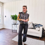 Washed black denim vest with ruffles at collar and sleeves, front pockets and silver buttons down the front.