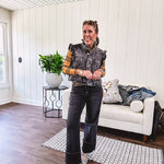Washed black denim vest with ruffles at collar and sleeves, front pockets and silver buttons down the front.