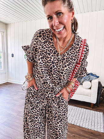 Lightweight leopard print short sleeved top with V neck and ruffled hem and cuffs.