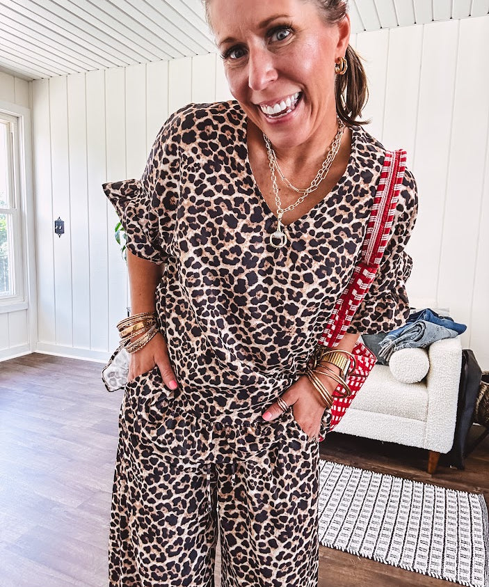 Lightweight leopard print short sleeved top with V neck and ruffled hem and cuffs.