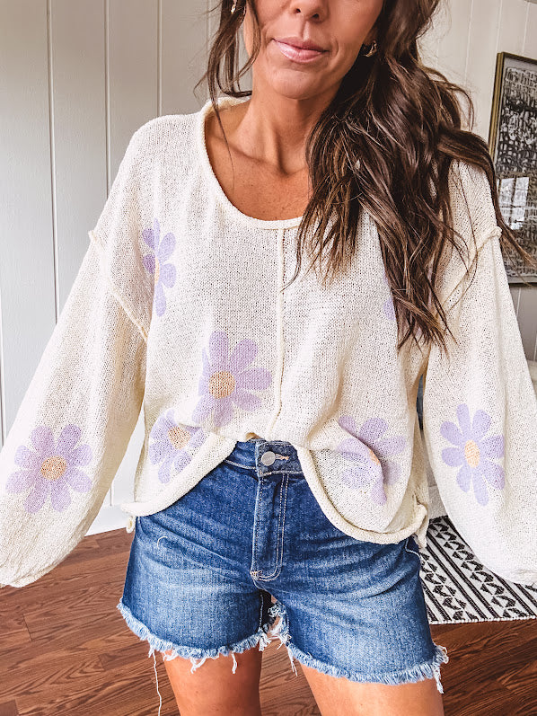 Soft, lightweight, nearly sheer knit pullover  with long sleeves, exposed seams at the shoulders and down the center with large daisy florals throughout. Available in multiple colors.