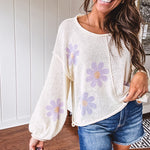 Soft, lightweight, nearly sheer knit pullover  with long sleeves, exposed seams at the shoulders and down the center with large daisy florals throughout. Available in multiple colors.