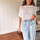 Open weave short sleeved waist length sweater available in many colors.