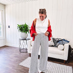 Wide leg black and white striped pants with stretch and pockets, button and zipper closure.
