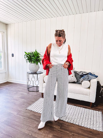 Wide leg black and white striped pants with stretch and pockets, button and zipper closure.