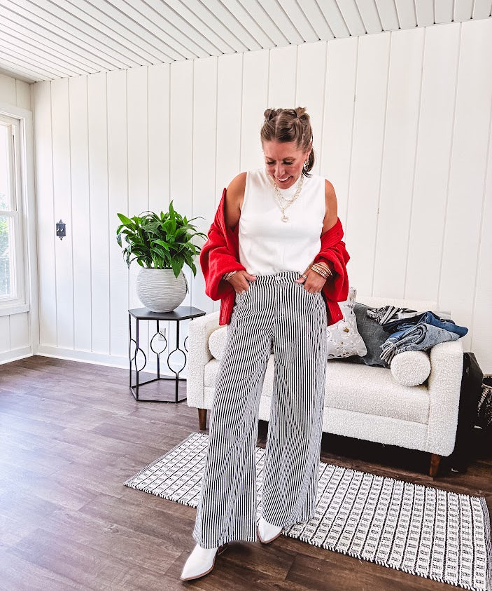 Wide leg black and white striped pants with stretch and pockets, button and zipper closure.