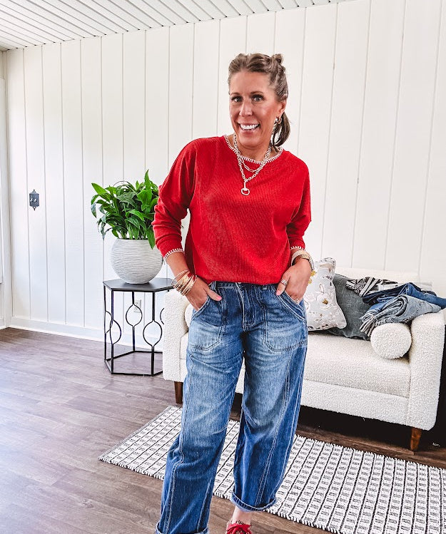 High rise medium wash barrel denim with unique side button detail on the waist and extra seam detail down the legs with large side pockets.