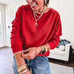 Light weight red ribbed long sleeved top with white whip stitching at the round neck and cuffs.