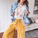 Light wash denim jacket with rope and grommet detail on the front.