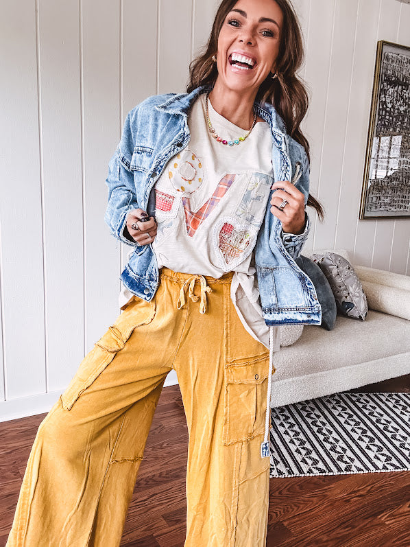 Light wash denim jacket with rope and grommet detail on the front.