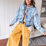 Light wash denim jacket with rope and grommet detail on the front.