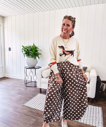Cream lightweight long sleeved sweater with Weiner Dog graphic on front with orange stripes at the sleeves.