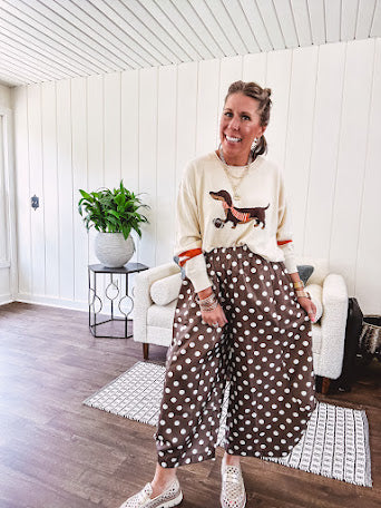 Cream lightweight long sleeved sweater with Weiner Dog graphic on front with orange stripes at the sleeves.