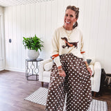 Cream lightweight long sleeved sweater with Weiner Dog graphic on front with orange stripes at the sleeves.