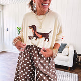 Cream lightweight long sleeved sweater with Weiner Dog graphic on front with orange stripes at the sleeves.