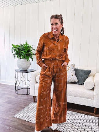 Lightweight rust button front long sleeved shirt with collar and white geometric stitching print throughout.