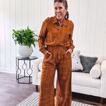 Wide leg rust pants with elastic waist and front pleats with geometric white stitching print throughout.