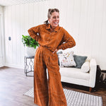 Wide leg rust pants with elastic waist and front pleats with geometric white stitching print throughout.