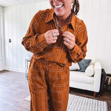 Lightweight rust button front long sleeved shirt with collar and white geometric stitching print throughout.