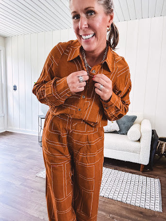 Lightweight rust button front long sleeved shirt with collar and white geometric stitching print throughout.