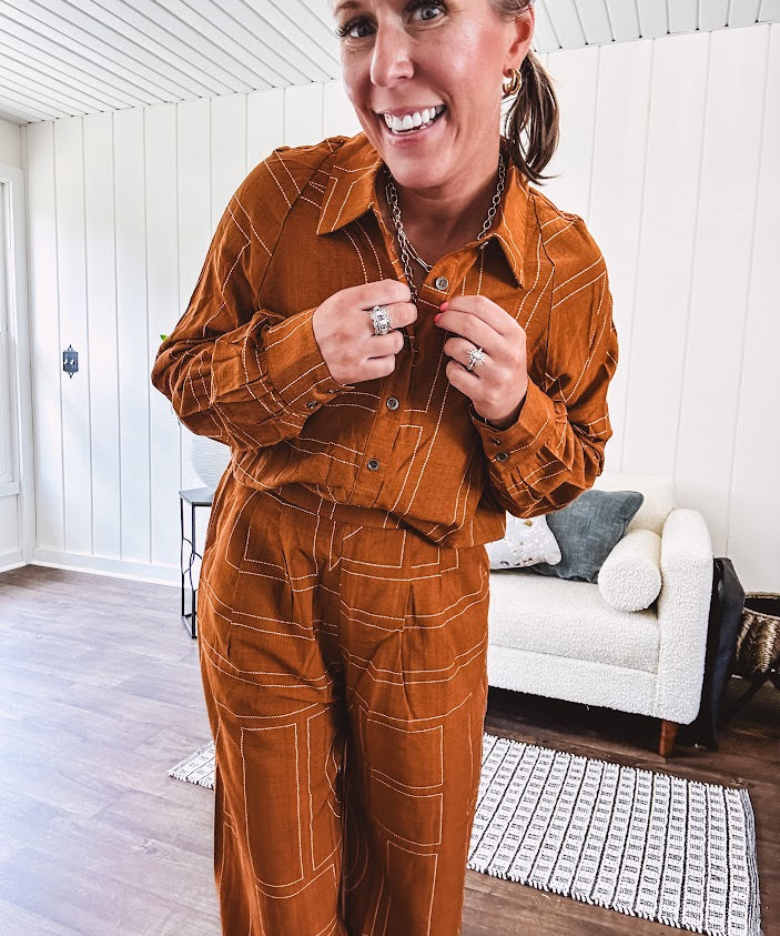 Lightweight rust button front long sleeved shirt with collar and white geometric stitching print throughout.