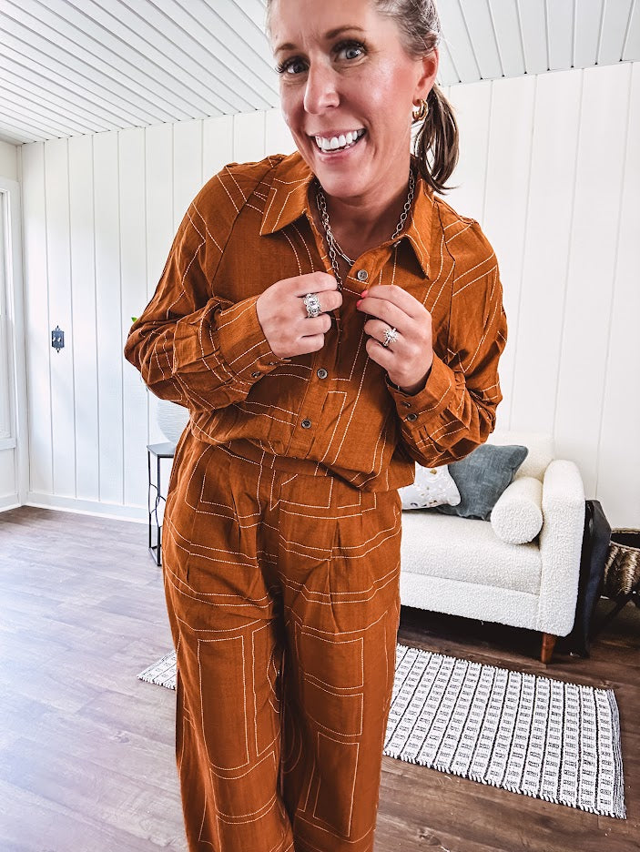 Lightweight rust button front long sleeved shirt with collar and white geometric stitching print throughout.