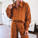Lightweight rust button front long sleeved shirt with collar and white geometric stitching print throughout.