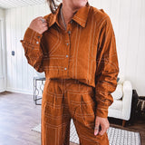 Lightweight rust button front long sleeved shirt with collar and white geometric stitching print throughout.