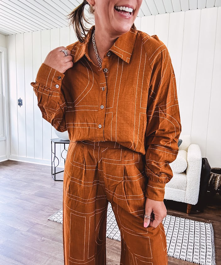 Lightweight rust button front long sleeved shirt with collar and white geometric stitching print throughout.