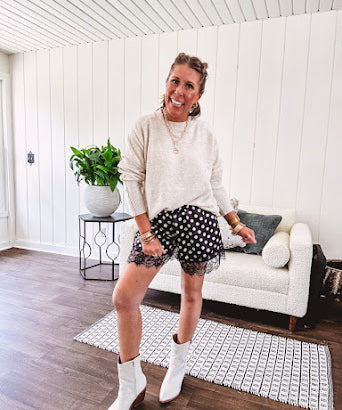 Black satin shorts with white polka dots, elastic waist and lace trim at the hems.