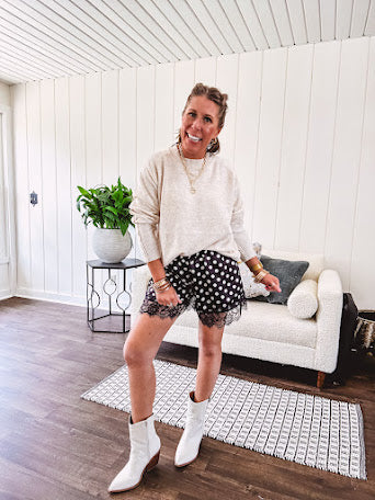Black satin shorts with white polka dots, elastic waist and lace trim at the hems.