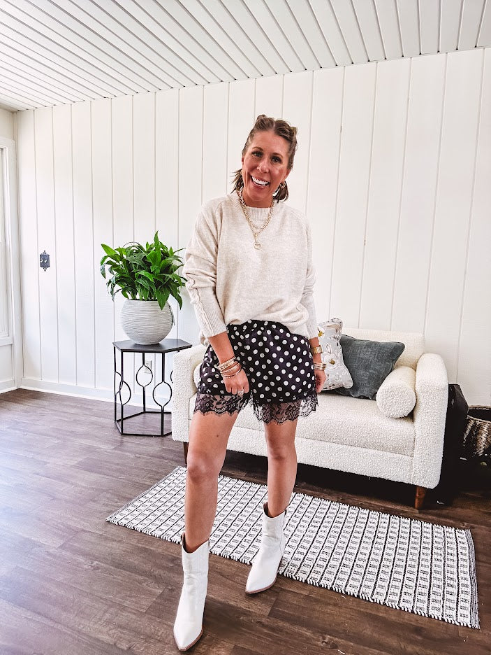 Black satin shorts with white polka dots, elastic waist and lace trim at the hems.
