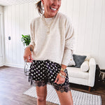 Black satin shorts with white polka dots, elastic waist and lace trim at the hems.