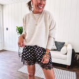 Black satin shorts with white polka dots, elastic waist and lace trim at the hems.