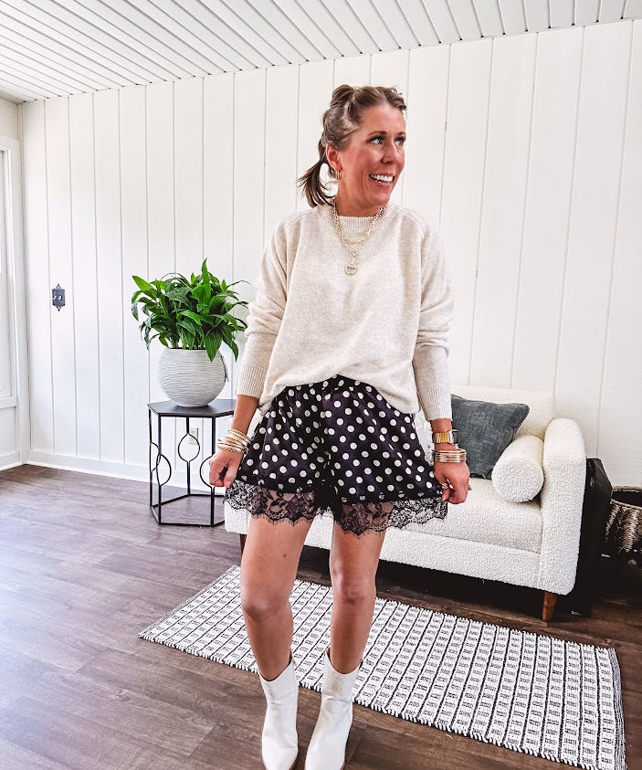 Black satin shorts with white polka dots, elastic waist and lace trim at the hems.
