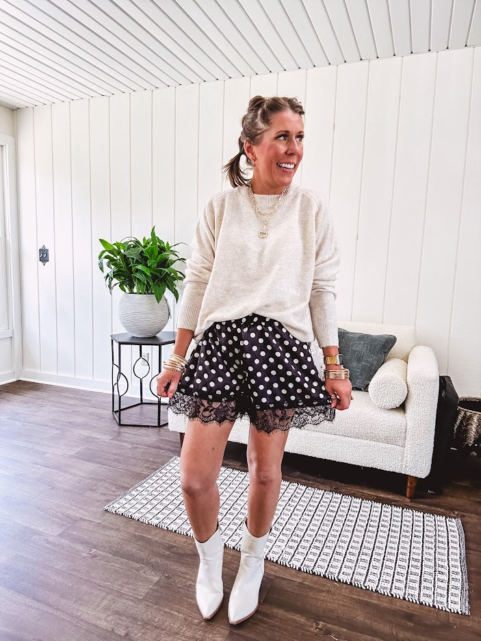 Black satin shorts with white polka dots, elastic waist and lace trim at the hems.
