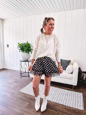 Black satin shorts with white polka dots, elastic waist and lace trim at the hems.
