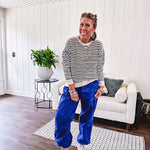 Lightweight black and cream striped crewneck sweater with royal blue contrast stripes at the shoulders, cuffs and hem.