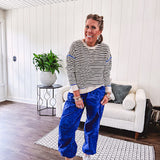 Lightweight black and cream striped crewneck sweater with royal blue contrast stripes at the shoulders, cuffs and hem.